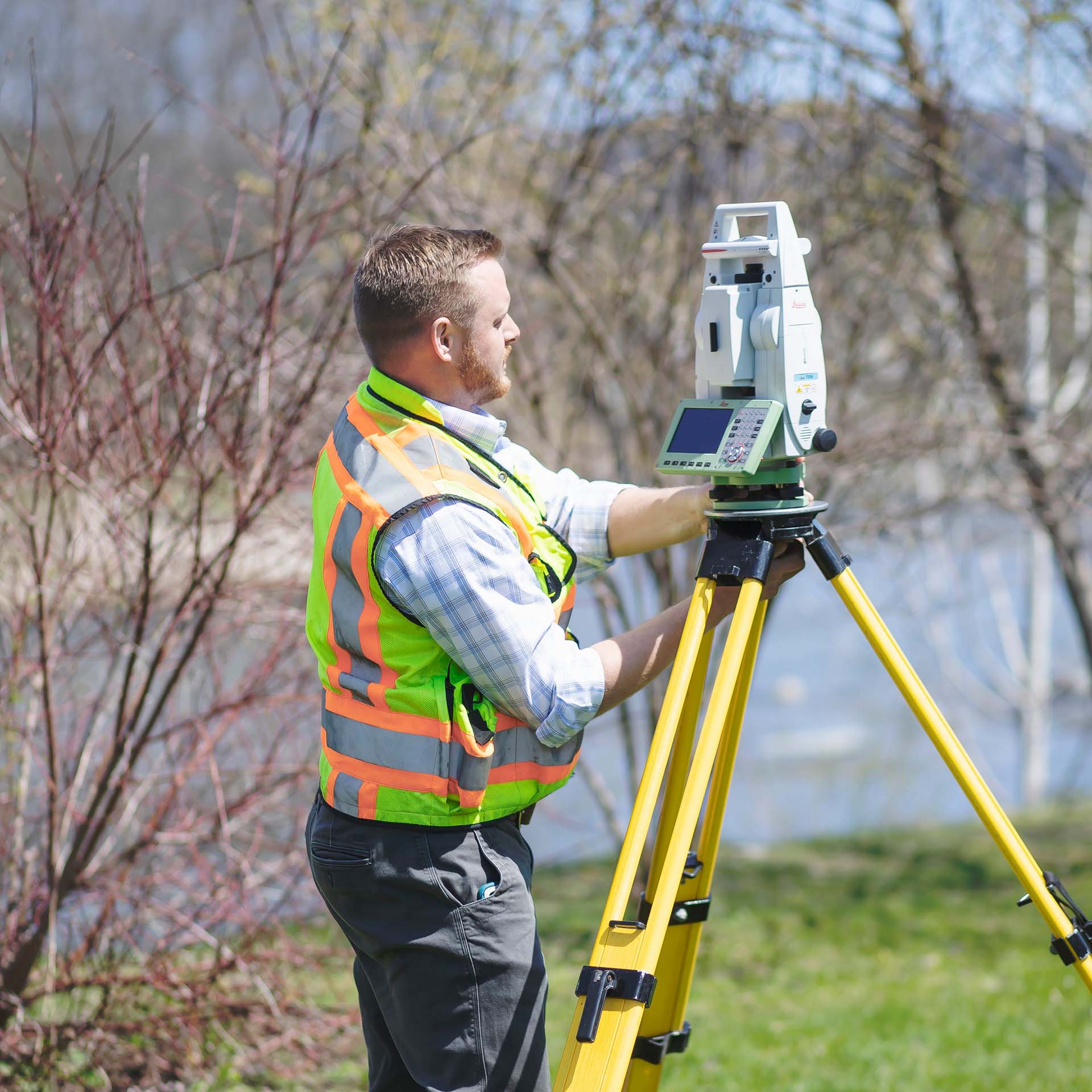 worker looking at surveying equipment