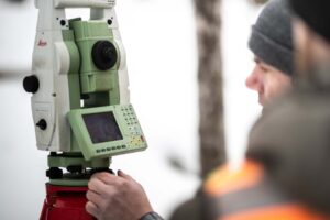 workers looking at survey equipment